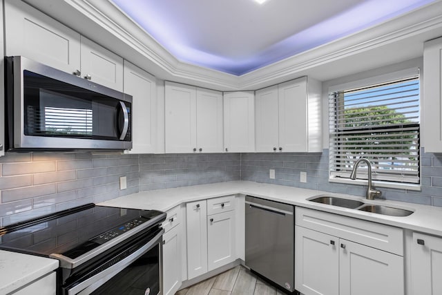 kitchen featuring white cabinets, sink, appliances with stainless steel finishes, and tasteful backsplash