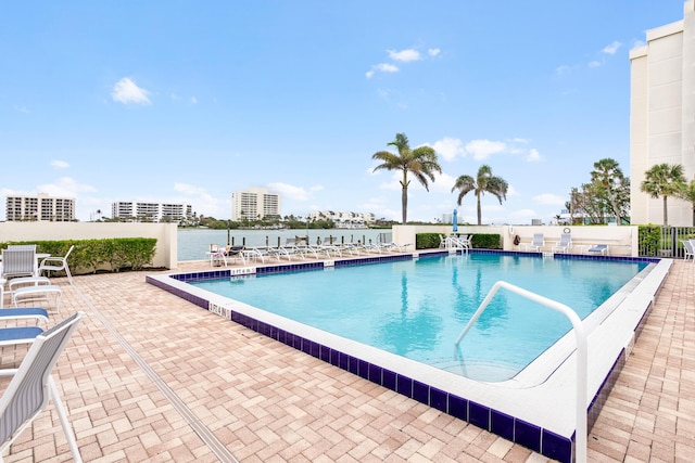 view of pool featuring a patio area and a water view