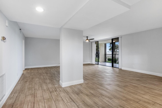 unfurnished room with a wall of windows and ceiling fan