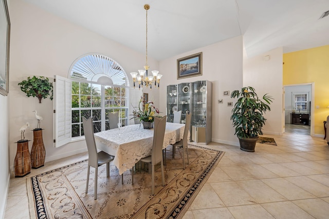 dining room featuring light tile patterned floors, a high ceiling, and an inviting chandelier