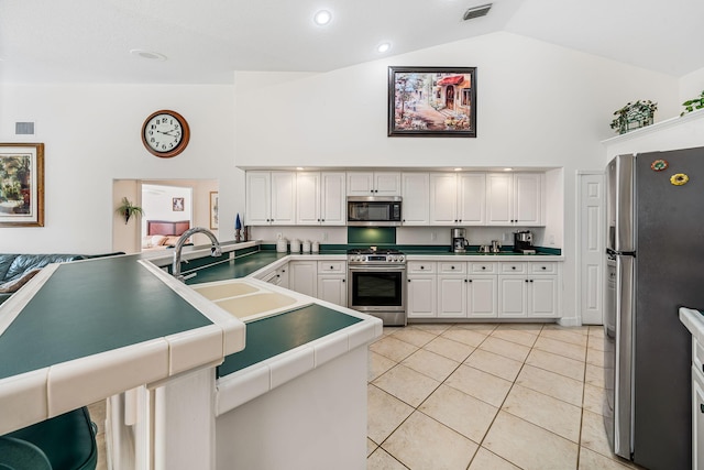 kitchen with tile countertops, white cabinets, sink, light tile patterned floors, and appliances with stainless steel finishes