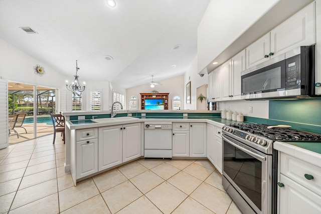 kitchen featuring white cabinets, kitchen peninsula, stainless steel appliances, and vaulted ceiling