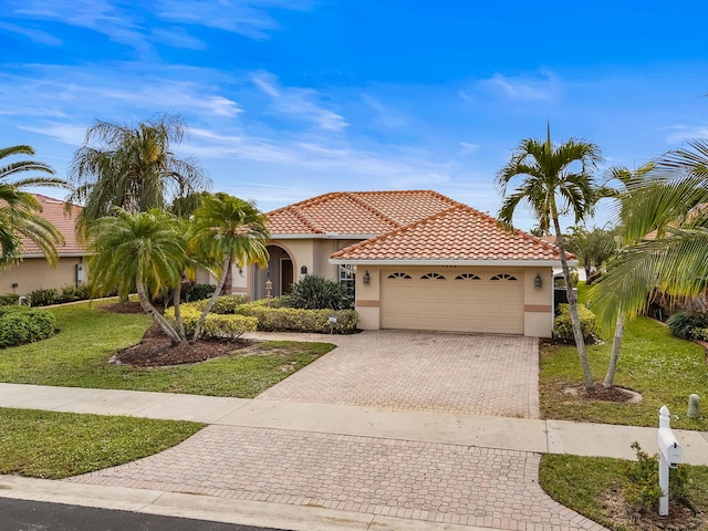 mediterranean / spanish-style house with a front yard and a garage