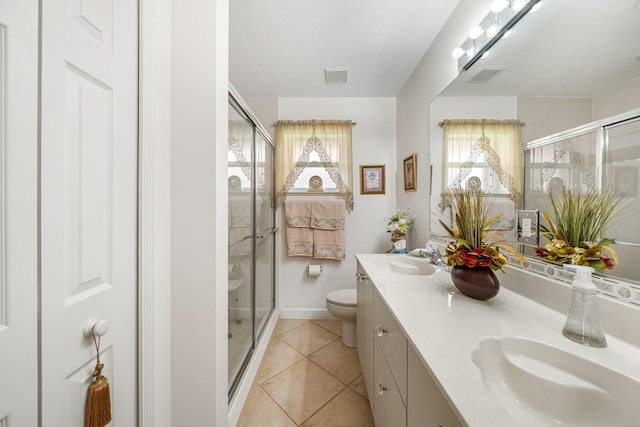 bathroom featuring tile patterned floors, vanity, toilet, and plenty of natural light