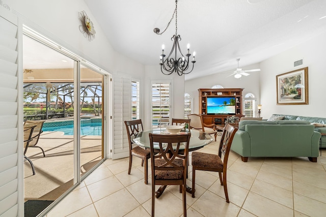 dining space featuring ceiling fan with notable chandelier, vaulted ceiling, and light tile patterned flooring