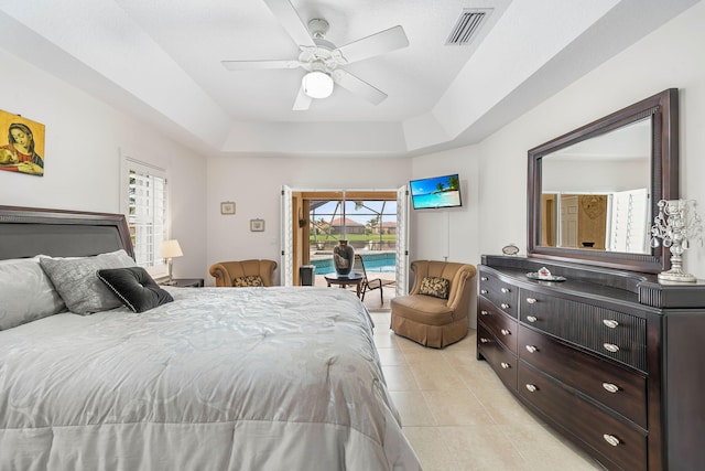 bedroom with access to exterior, ceiling fan, and a raised ceiling