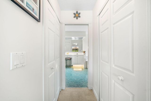 hallway featuring light colored carpet