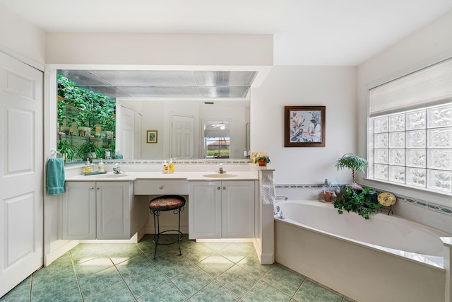 bathroom with a tub, tile patterned flooring, and vanity