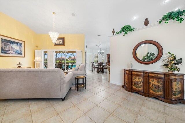 living room featuring light tile patterned floors, vaulted ceiling, and a notable chandelier