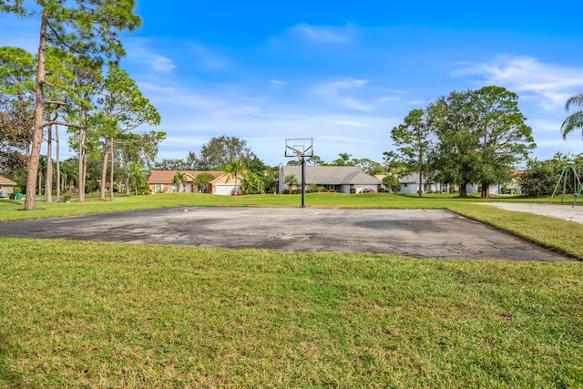 view of basketball court with a yard