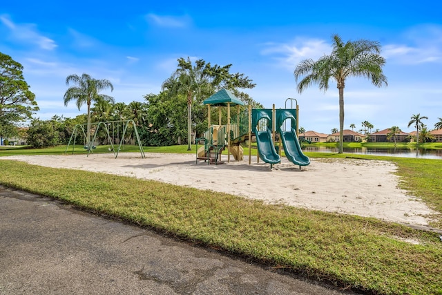 view of jungle gym featuring a lawn and a water view