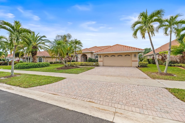 mediterranean / spanish house with a garage and a front lawn