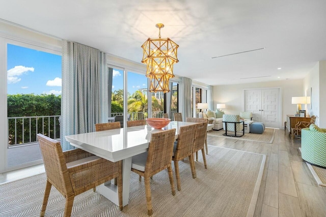 dining room with light wood-type flooring and a chandelier