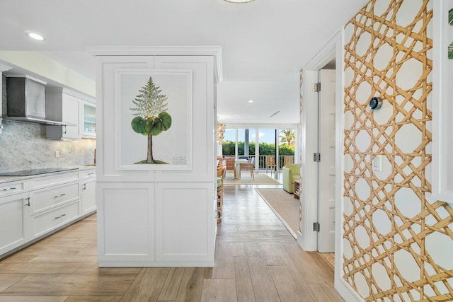 corridor with light wood-type flooring and crown molding