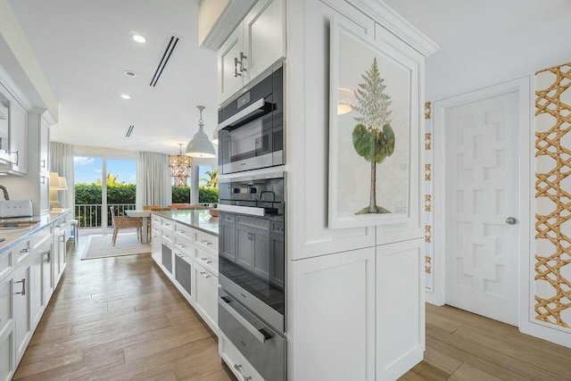 kitchen featuring white cabinetry, pendant lighting, and stainless steel appliances