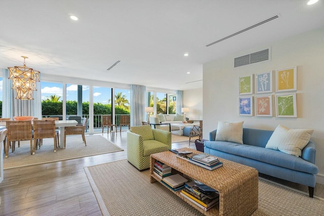 living area with recessed lighting, wood finished floors, visible vents, and an inviting chandelier