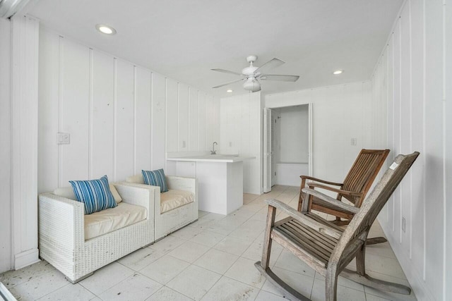 sitting room featuring ceiling fan and sink