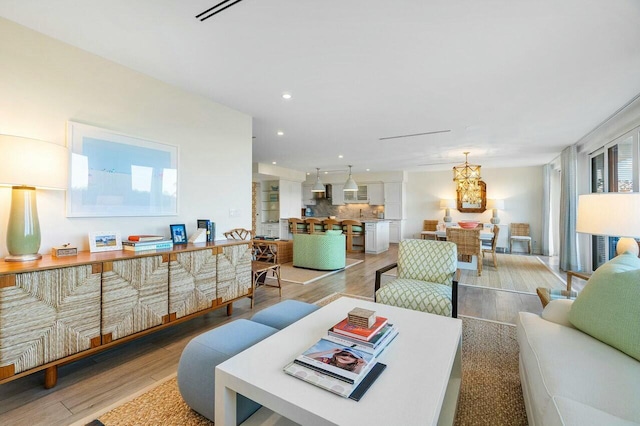 living room with light hardwood / wood-style flooring and a chandelier