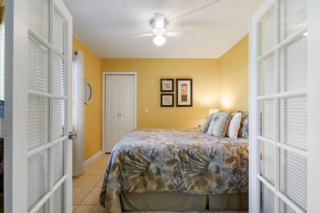 tiled bedroom featuring french doors, a textured ceiling, and ceiling fan