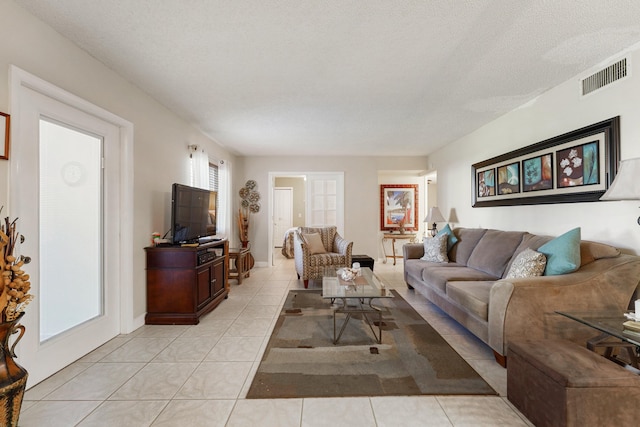 tiled living room featuring a textured ceiling