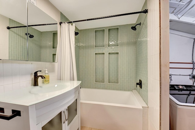 bathroom featuring washer / clothes dryer, sink, and shower / bathtub combination with curtain