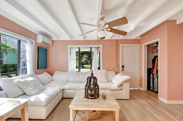 living room with ceiling fan, plenty of natural light, a wall mounted air conditioner, and light wood-type flooring