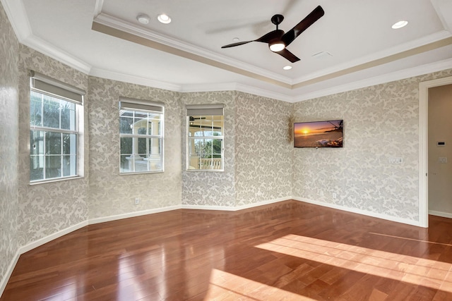 unfurnished room with wood-type flooring, a raised ceiling, and crown molding