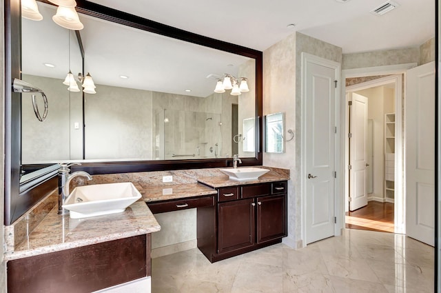 bathroom with vanity, a chandelier, and an enclosed shower