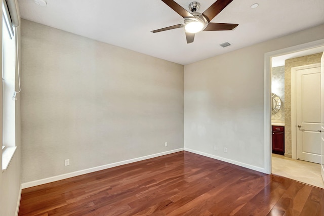 unfurnished bedroom with connected bathroom, ceiling fan, and wood-type flooring