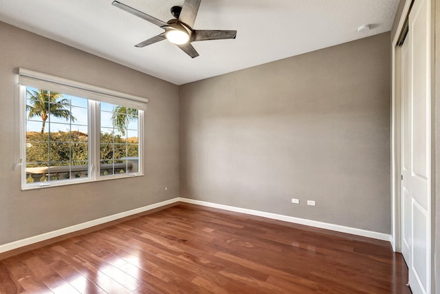 unfurnished room featuring ceiling fan and dark wood-type flooring