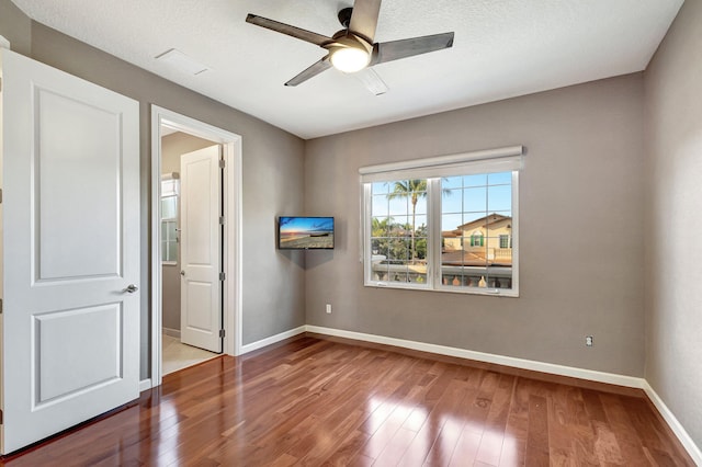 unfurnished bedroom with wood-type flooring, a textured ceiling, and ceiling fan