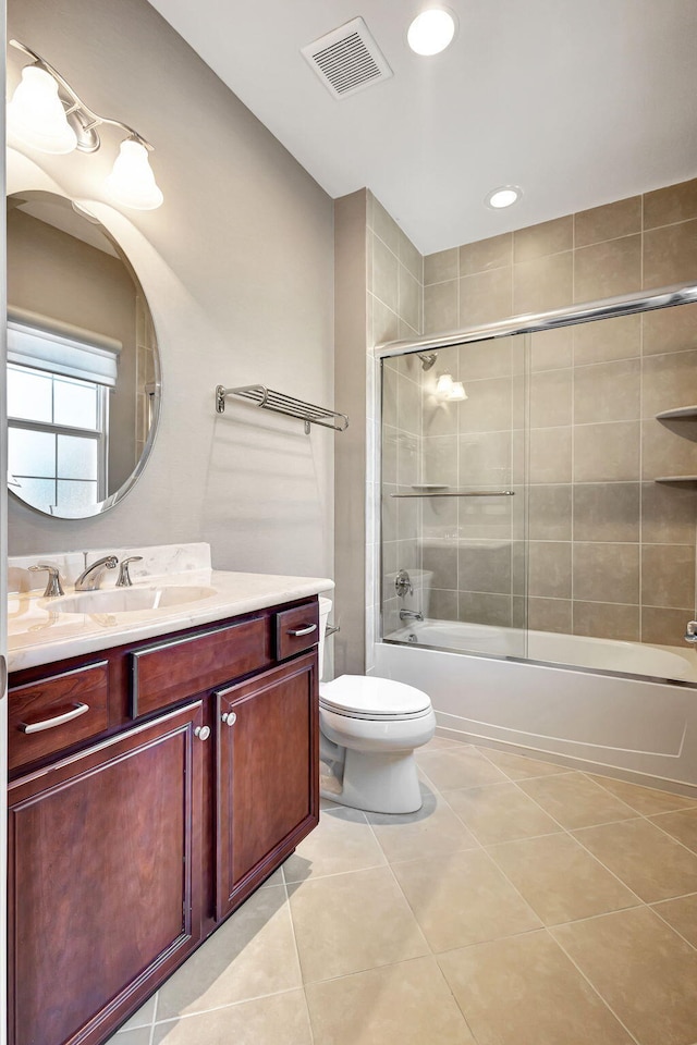 full bathroom featuring tile patterned flooring, vanity, bath / shower combo with glass door, and toilet