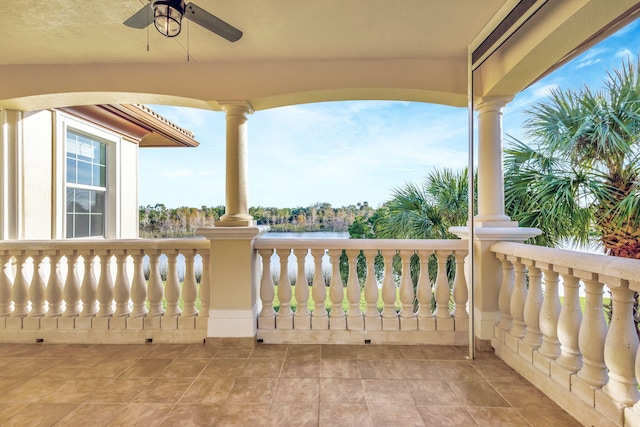 view of patio featuring ceiling fan, a balcony, and a water view