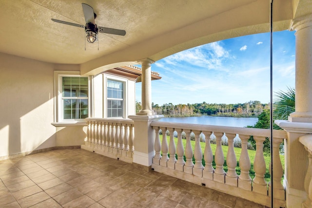 balcony with ceiling fan and a water view