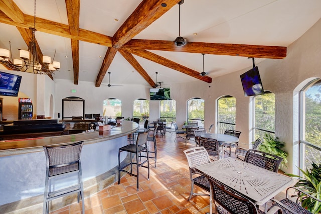 kitchen featuring beam ceiling, ceiling fan with notable chandelier, and plenty of natural light