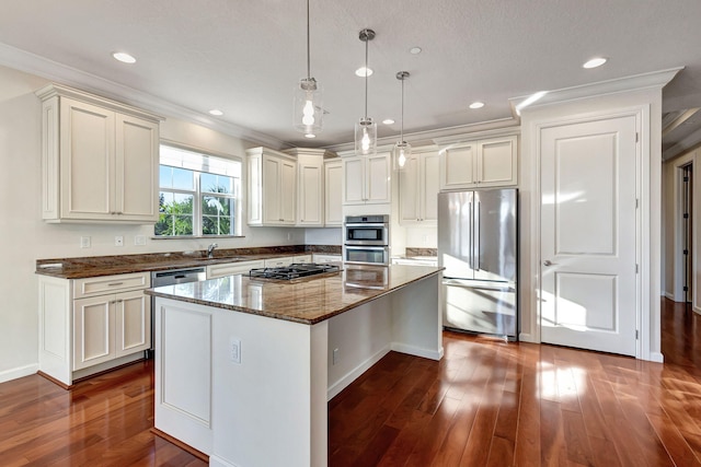 kitchen with crown molding, dark stone counters, decorative light fixtures, a kitchen island, and appliances with stainless steel finishes