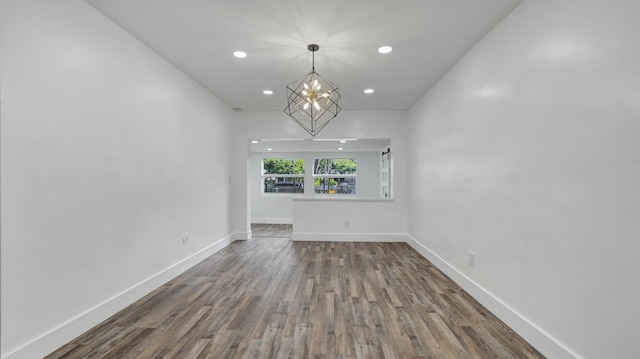 unfurnished living room featuring a chandelier and wood-type flooring