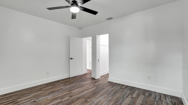 spare room featuring ceiling fan and dark wood-type flooring