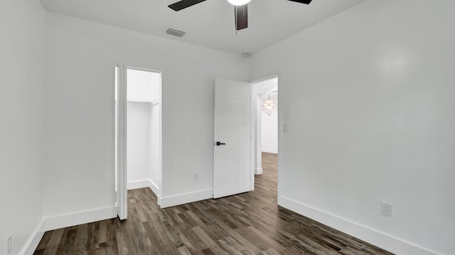 empty room with ceiling fan and dark hardwood / wood-style flooring