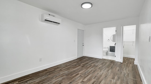 spare room with dark hardwood / wood-style floors and a wall mounted AC