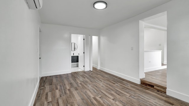 unfurnished room featuring a wall mounted air conditioner and wood-type flooring