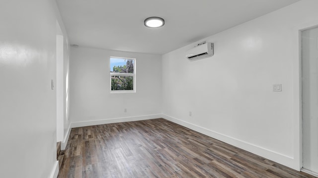 spare room with dark wood-type flooring and a wall unit AC