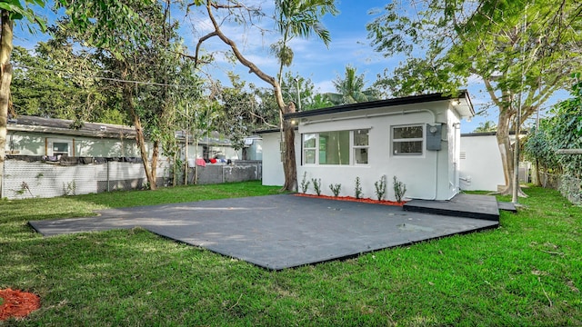 back of house featuring a patio and a lawn