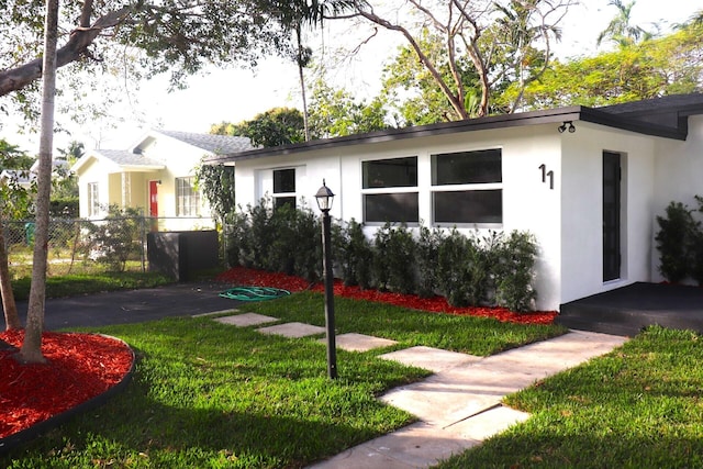 ranch-style home featuring a front lawn