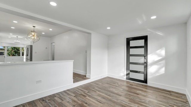 foyer entrance featuring hardwood / wood-style flooring and a notable chandelier