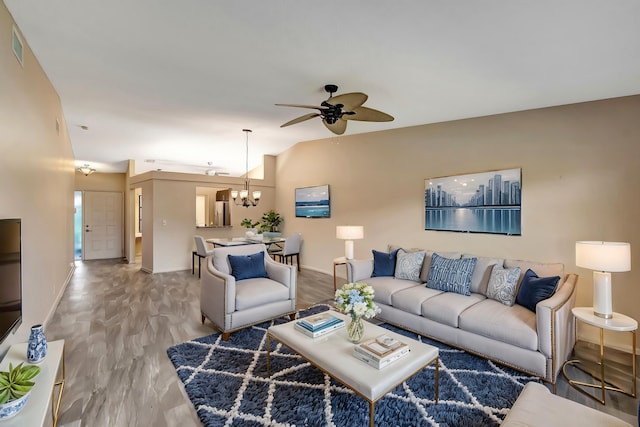 living room with ceiling fan with notable chandelier