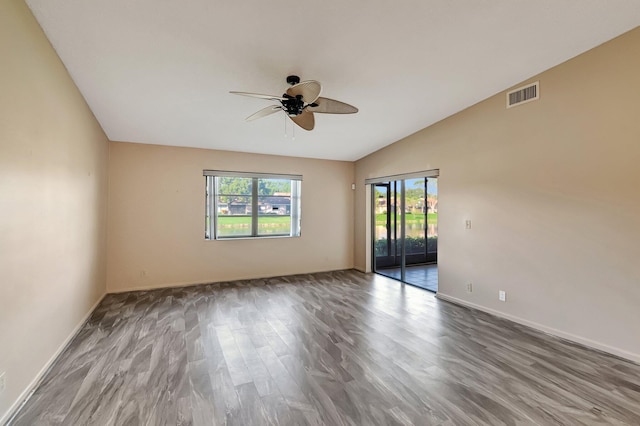 spare room with ceiling fan, wood-type flooring, and vaulted ceiling