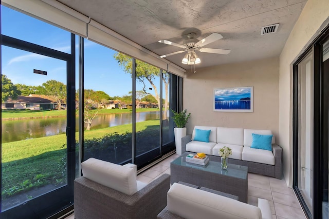 sunroom / solarium with ceiling fan and a water view