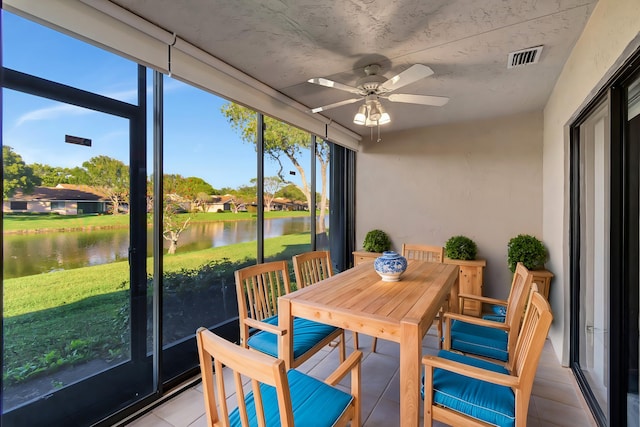 sunroom / solarium with a water view and ceiling fan