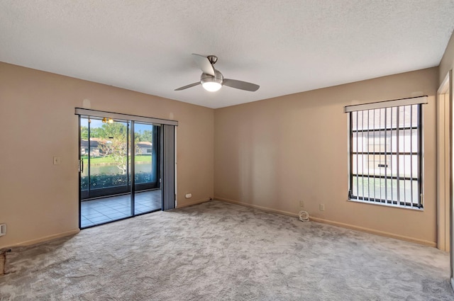 carpeted spare room with ceiling fan and a textured ceiling